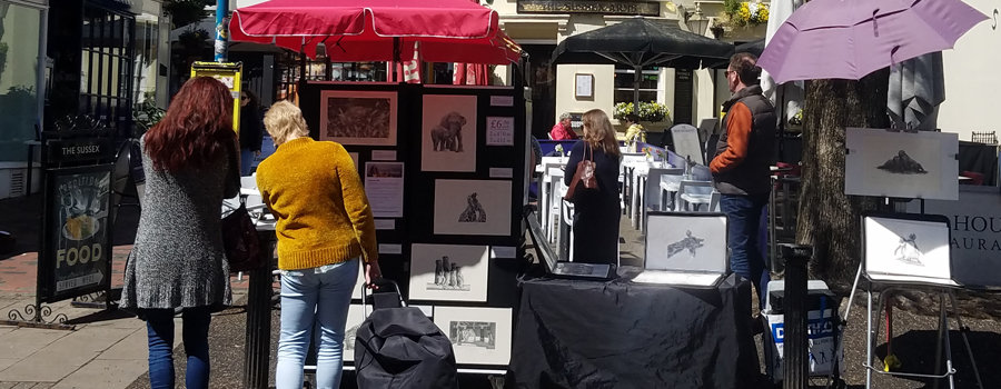How to prepare for an outdoor art fair feature image. Two ladies buying art on a sunny day